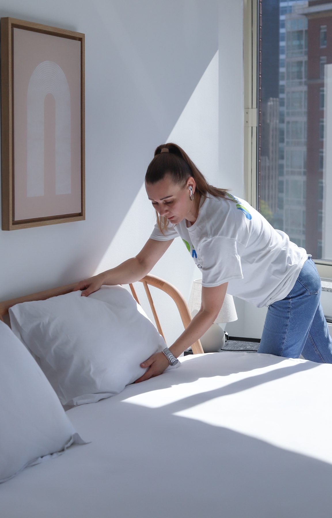 Cleaning Master professional making a bed with fresh linens during a move-in cleaning