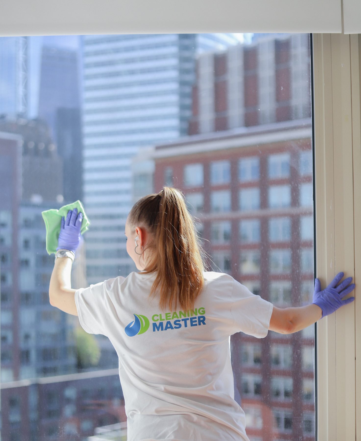 Cleaning Master professional cleaning a Manhattan high-rise window above the city